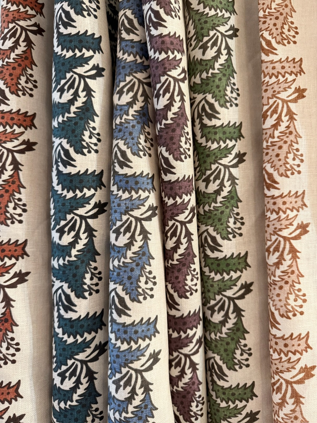 Bastideaux Amaya textile shown in blue, rust, plum, green and ochre colorways