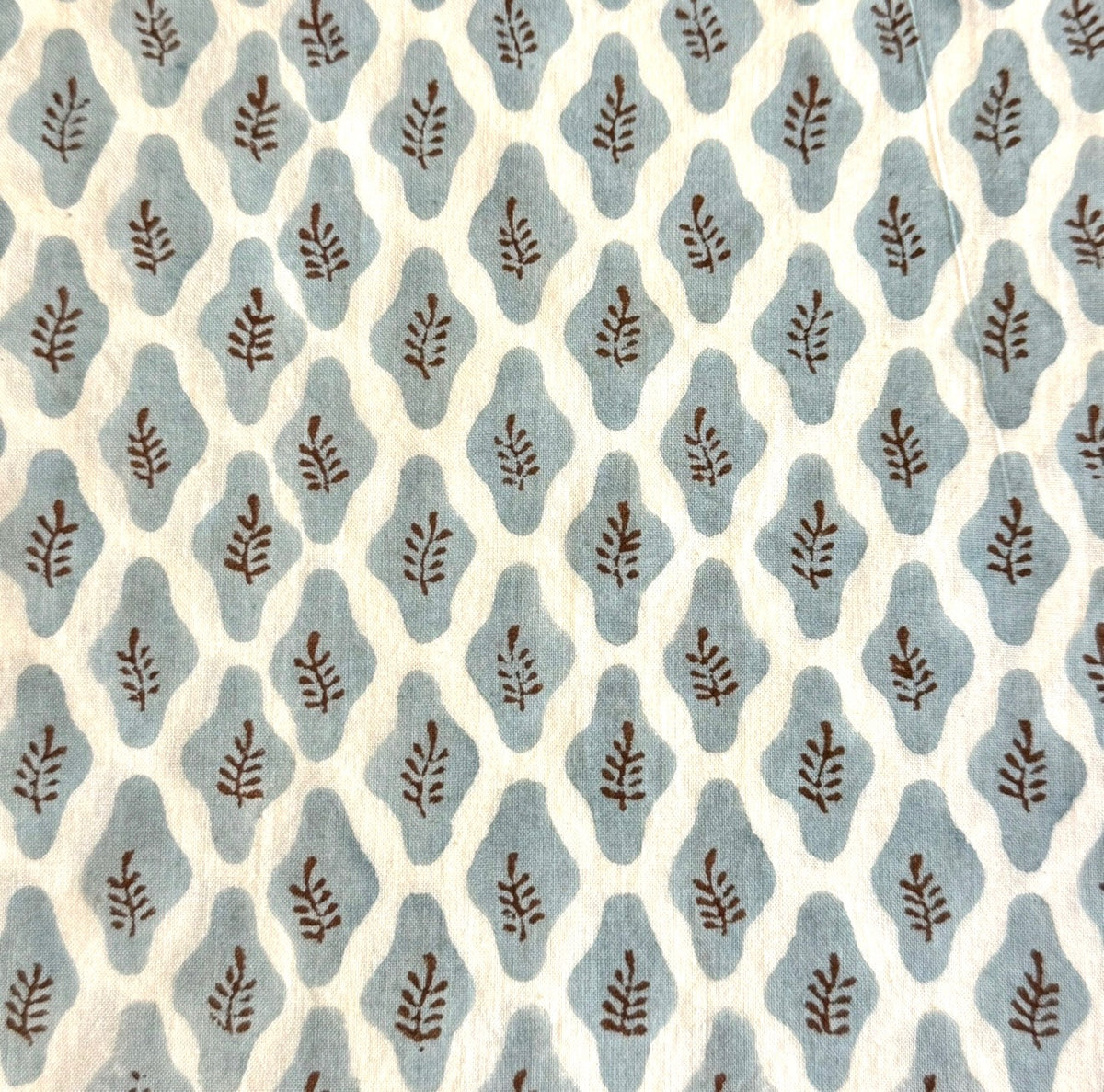 Bastideaux Fiesole Stone Blue textile with blue organic motifs and brown leaf details on a cream ground
