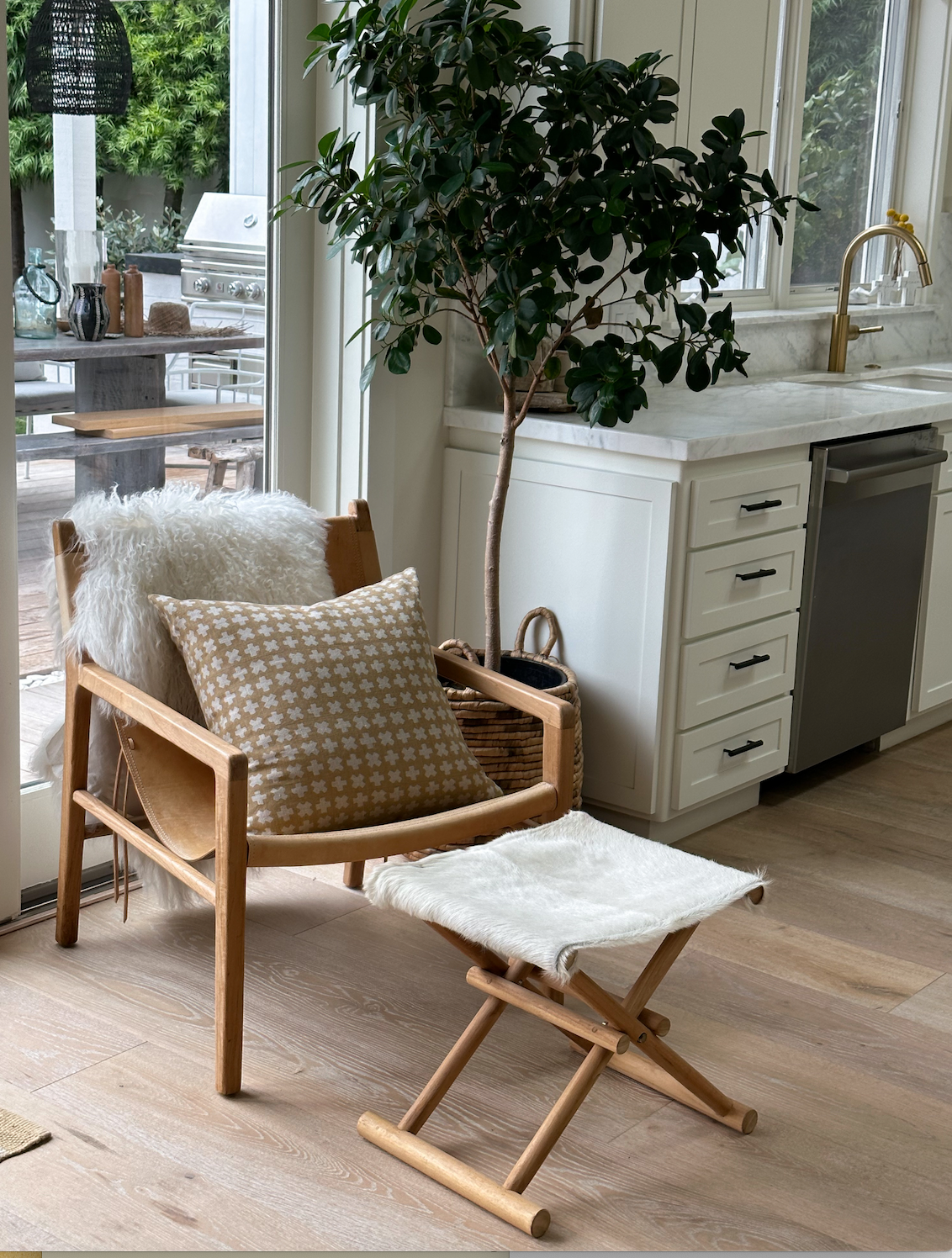 Bastideaux Bogo pillow in warm ochre with ivory geometric motifs styled on a wood chair