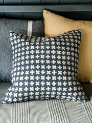 Bastideaux Bogo pillow in Midnight with natural flax cross motifs styled with charcoal and ochre pillows