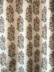 A close-up of a window drapery with a floral pattern in various colors including pink, orchid, and rose.